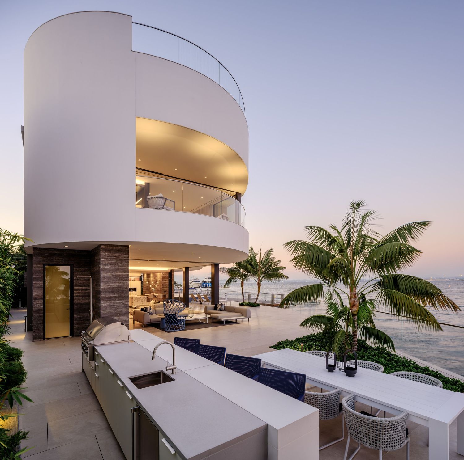 Coronado 3 The Point luxury waterfront home with curved architecture, outdoor kitchen, and bayfront terrace at dusk