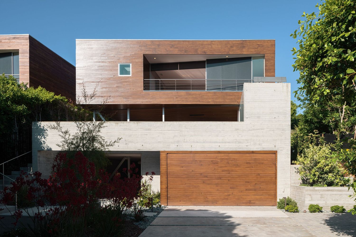 Front elevation of 7003 Fay Avenue, a modern La Jolla residence by architect Sebastian Mariscal, featuring concrete and wood volumes.