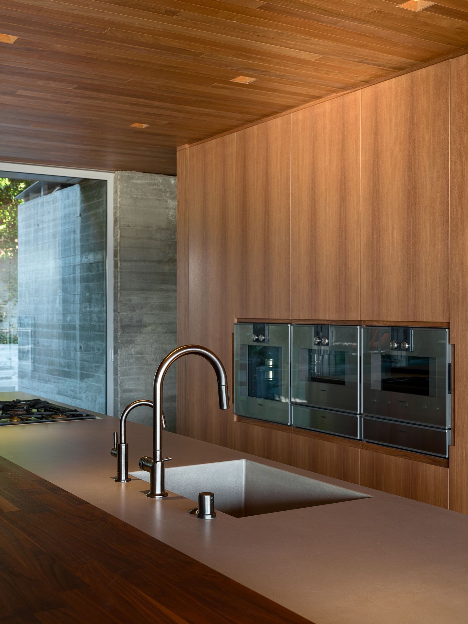 Kitchen detail at 7003 Fay Avenue with integrated appliances, warm wood surfaces, and refined modern craftsmanship.