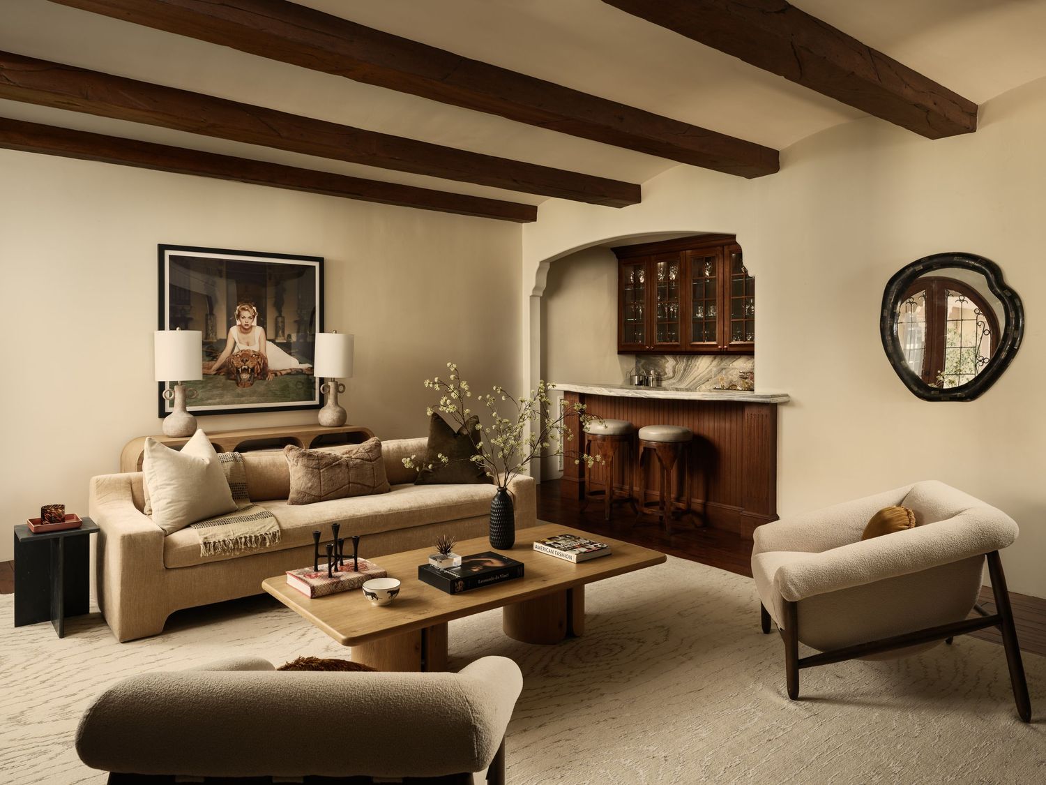 Casa De La Vista living room at 7757 Whitefield Pl with exposed beams, neutral seating, and arched wet bar in La Jolla.