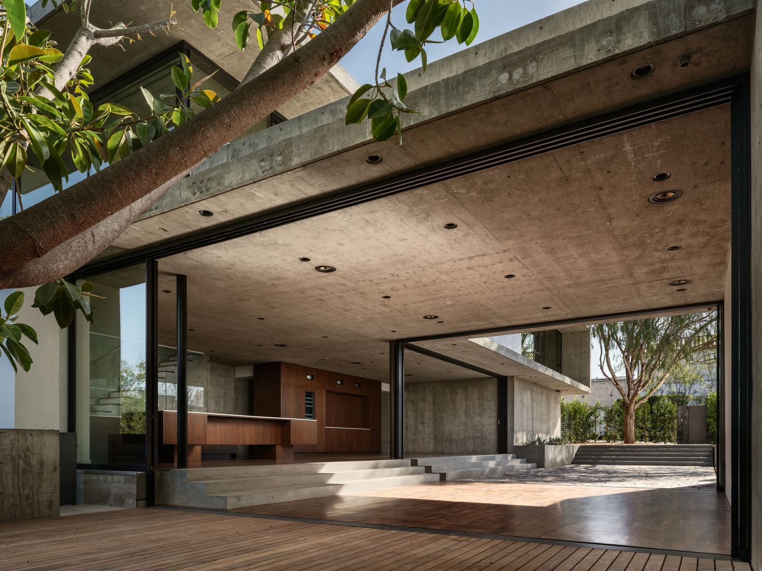 Arista Residence covered terrace by Matthew Segal, modern concrete architecture opening to outdoor living space.