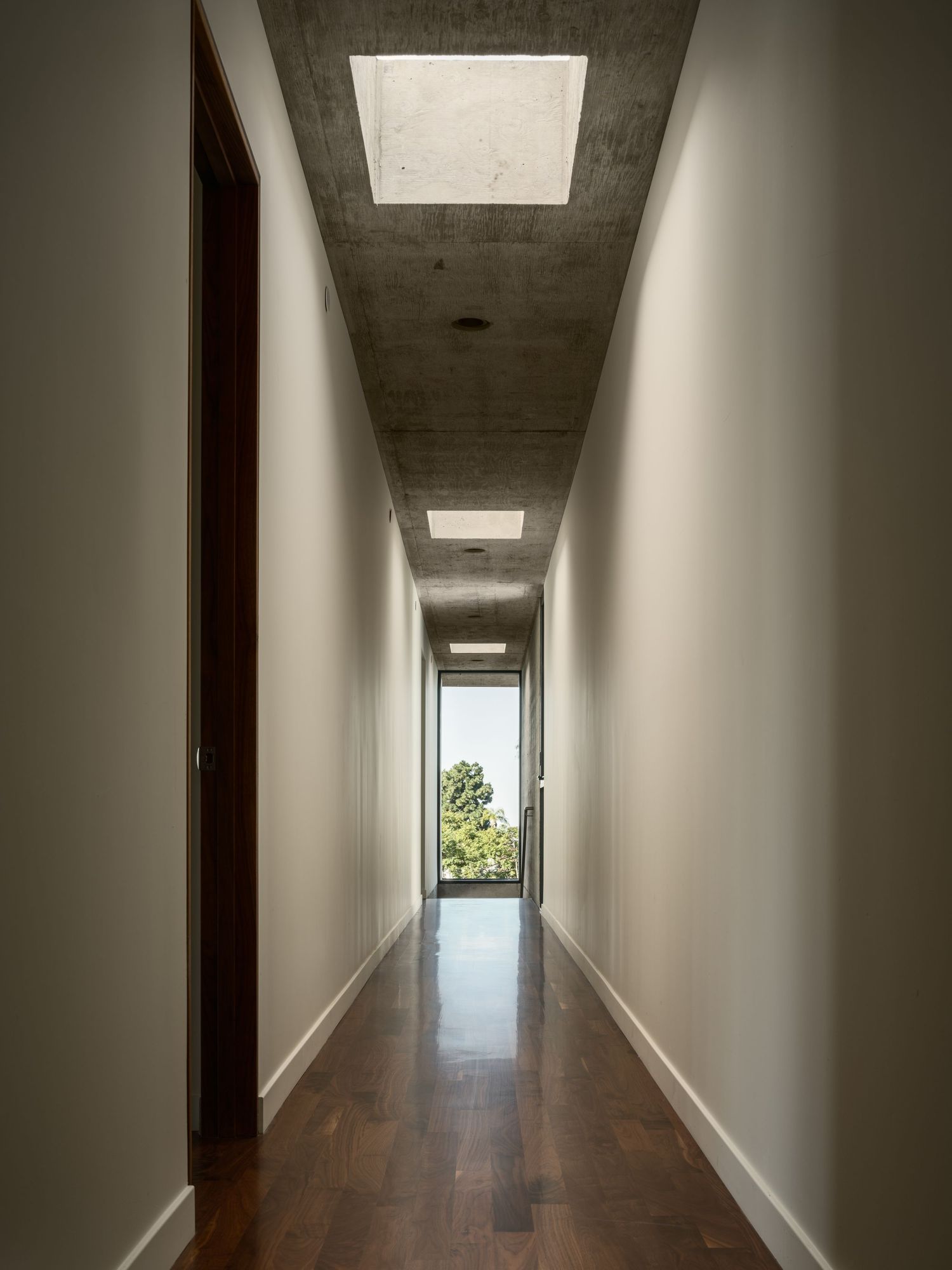 Arista Residence hallway interior by Matthew Segal, minimalist corridor with skylights and wood floor—architectural photo by Luca Prodi.