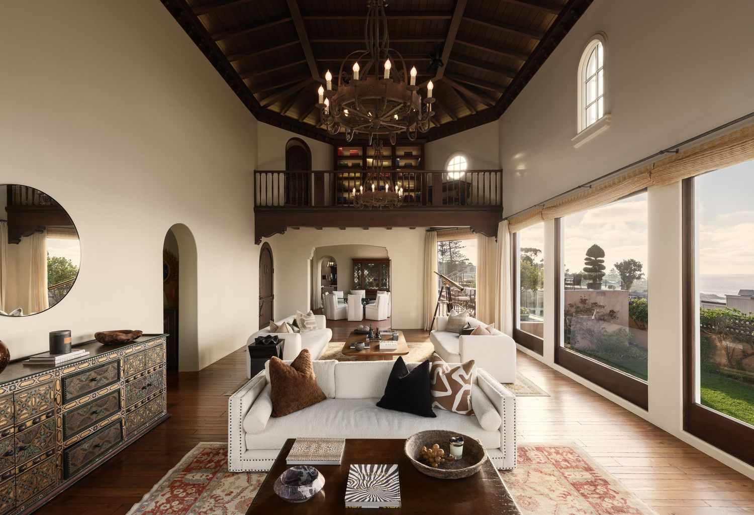 Luxury real estate photo of 7757 Whitefield great room with vaulted wood ceiling, mezzanine balcony, chandeliers, and ocean views.