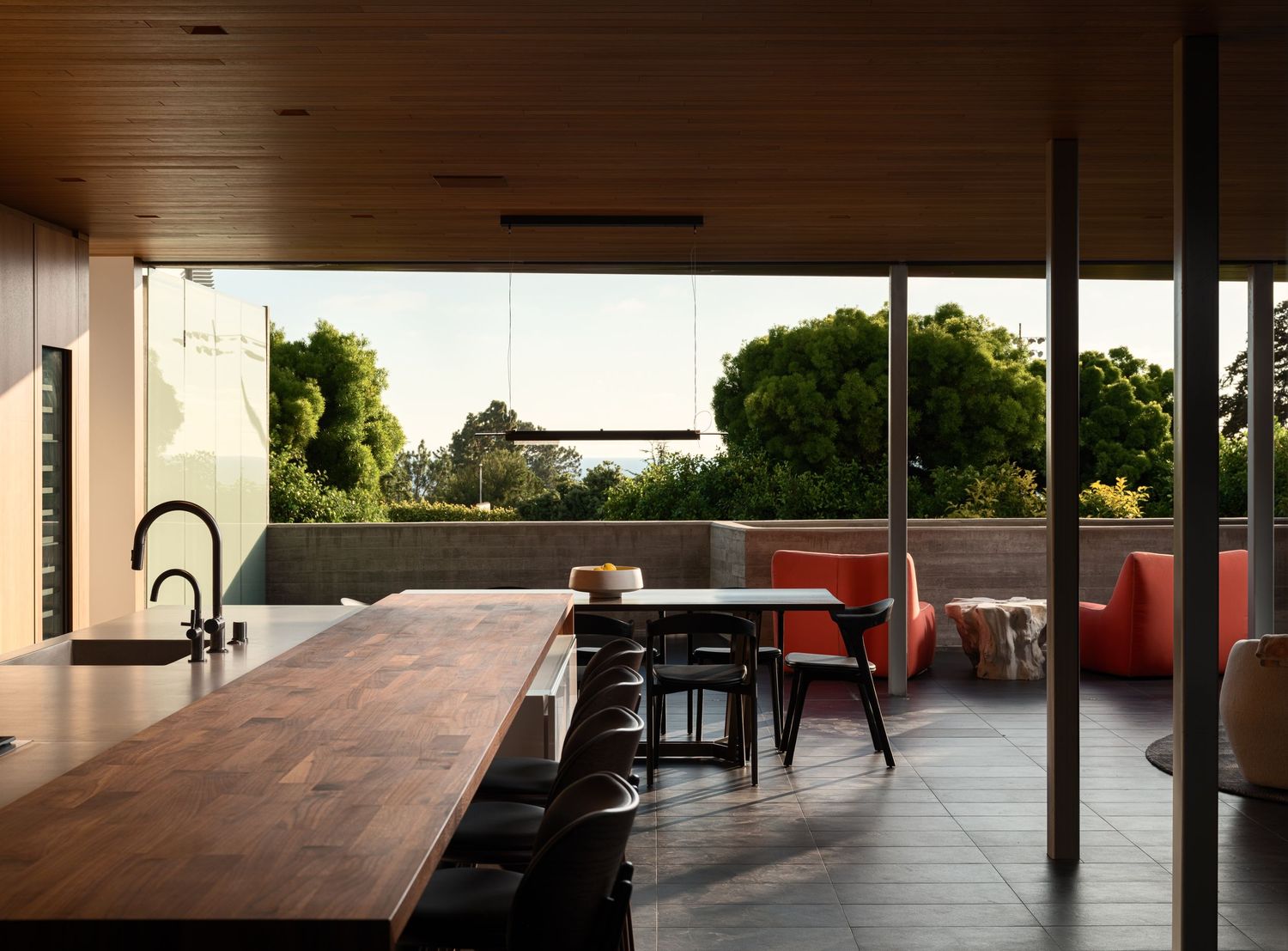 Open kitchen and dining area at 7003 Fay Avenue opening to a terrace, emphasizing indoor-outdoor living and clean modern lines.