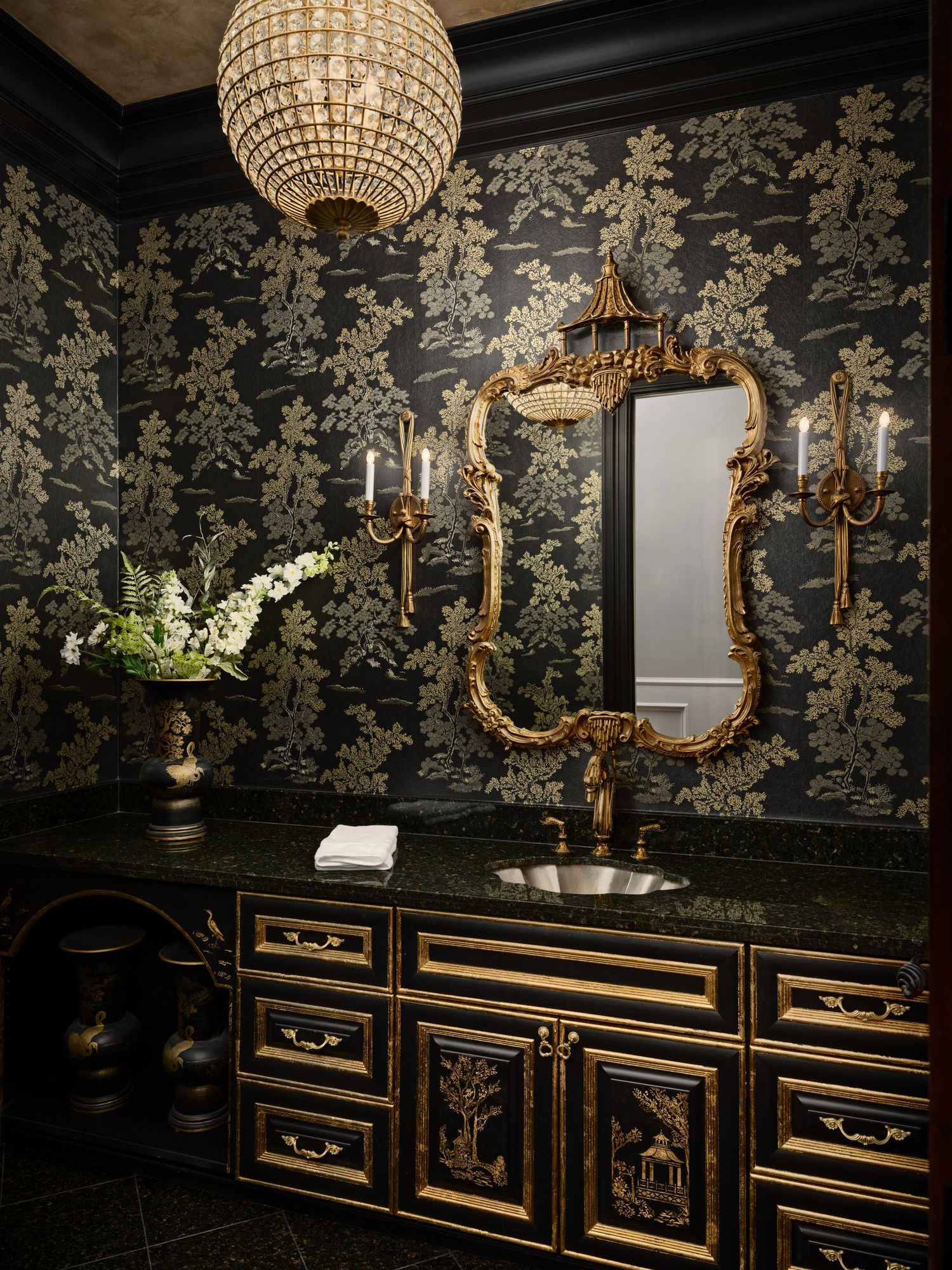 Elegant powder room with gold mirror, dark floral walls, and custom cabinetry photographed for a high-end interior design project.