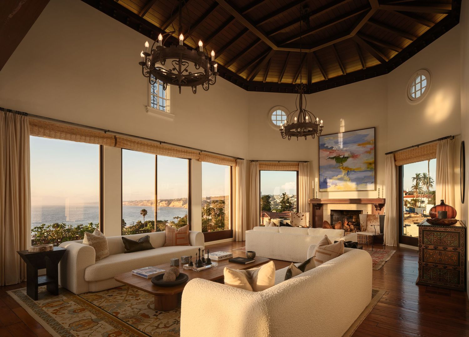 Luxury real estate photo of 7757 Whitefield living room with vaulted ceiling, chandeliers, ocean-view windows, and fireplace.