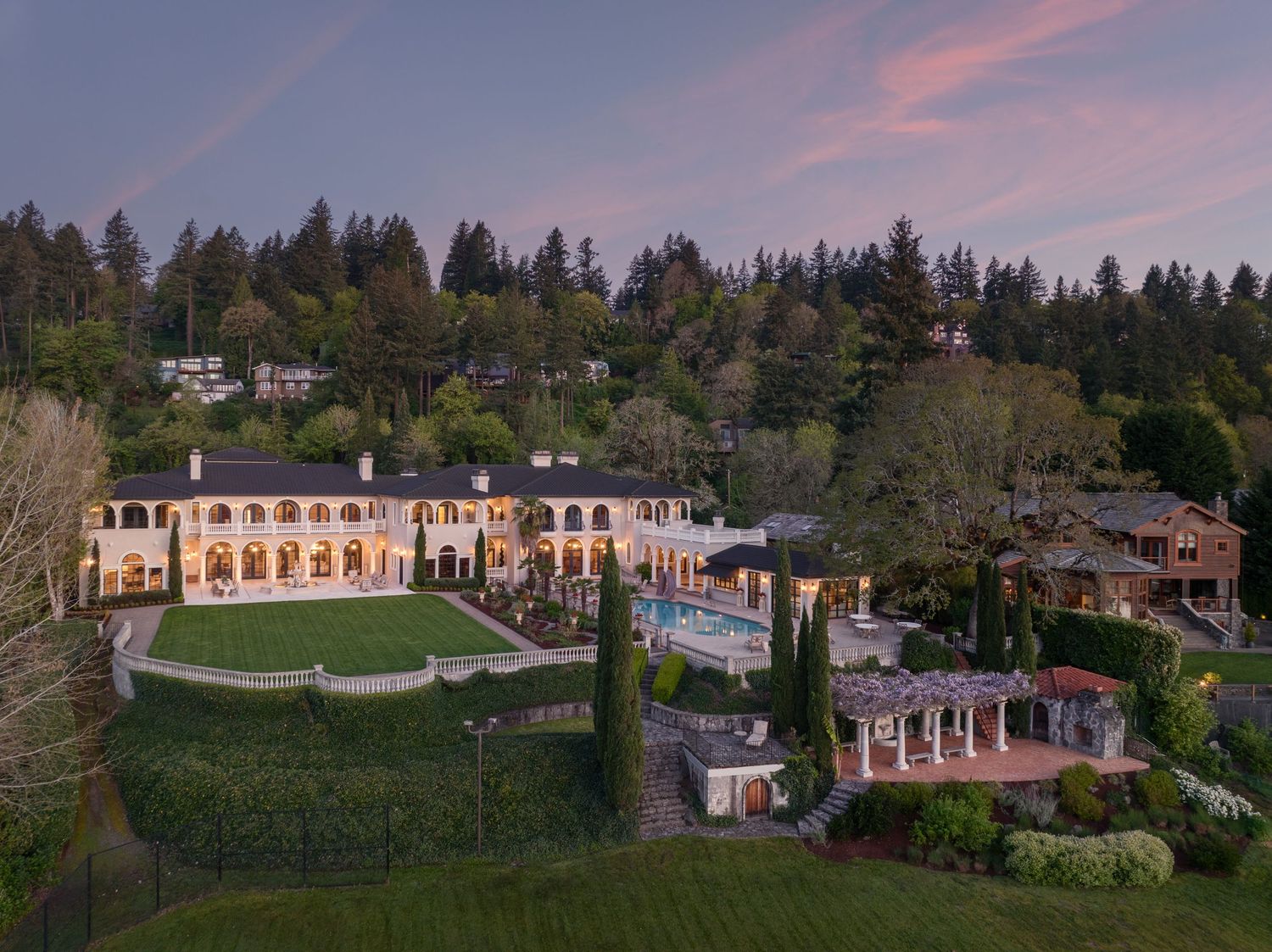Twilight aerial photo of Fielding House in Lake Oswego, highlighting the estate’s gardens, terraces, and waterfront setting.