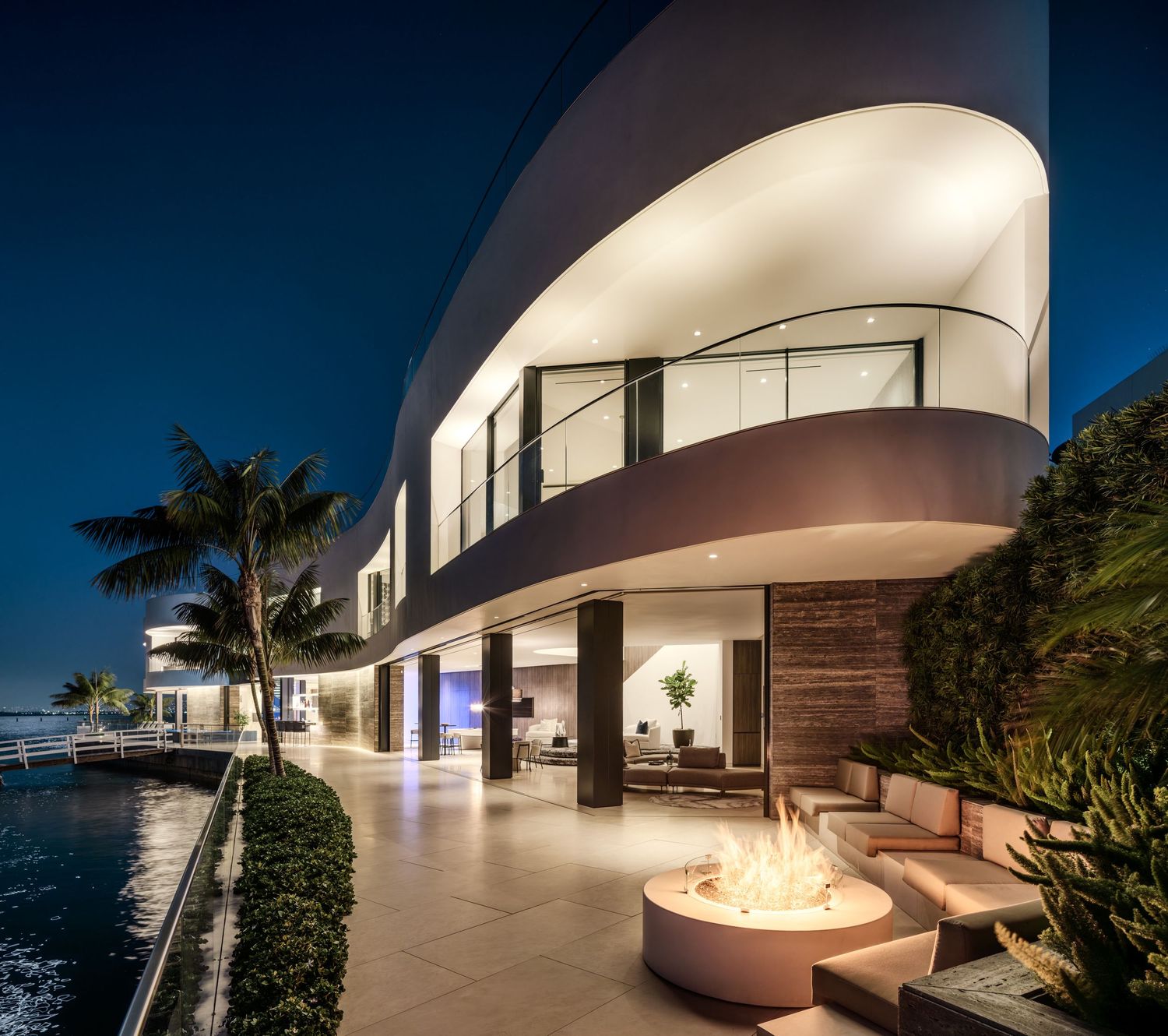 Coronado 3 The Point waterfront terrace with fire pit, curved modern architecture, and evening bay views