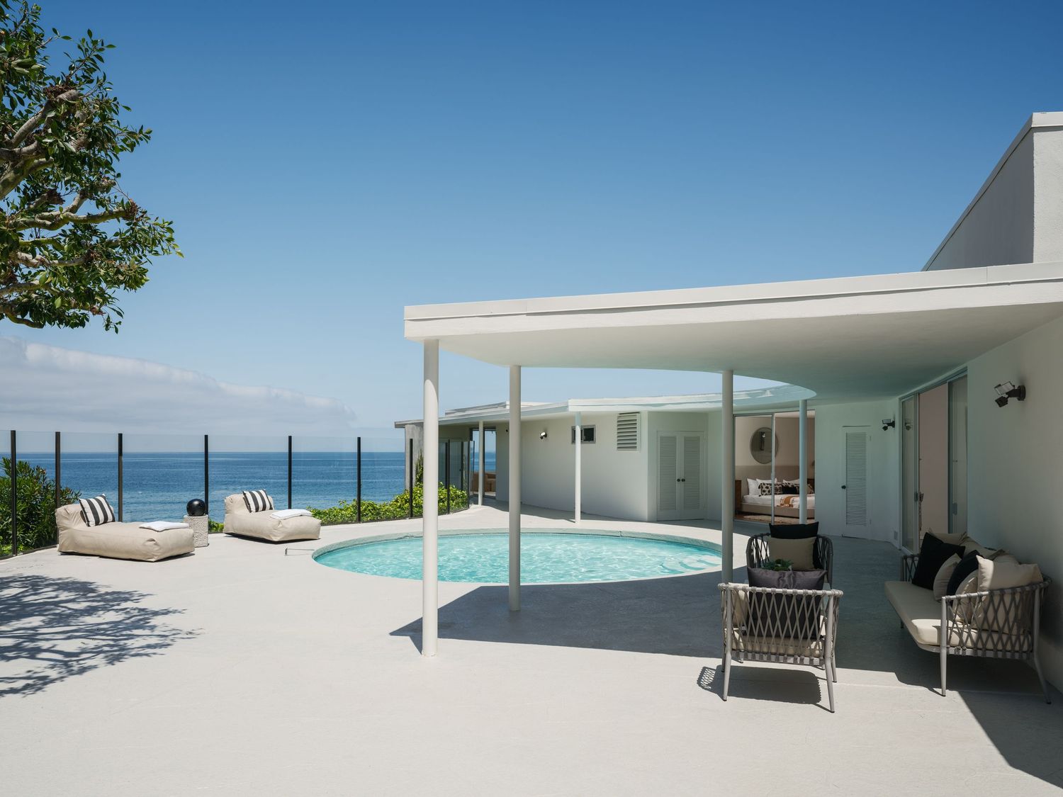 Oceanfront pool courtyard at 1890 Spindrift Drive featuring clean modern lines, covered terrace, and direct Pacific Ocean views.