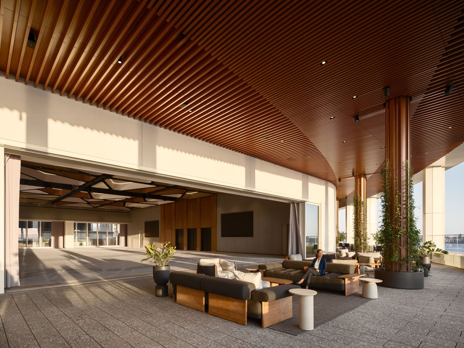 Open commercial lounge featuring Acoufelt acoustic ceiling panels, indoor-outdoor design, and modern workplace architecture.