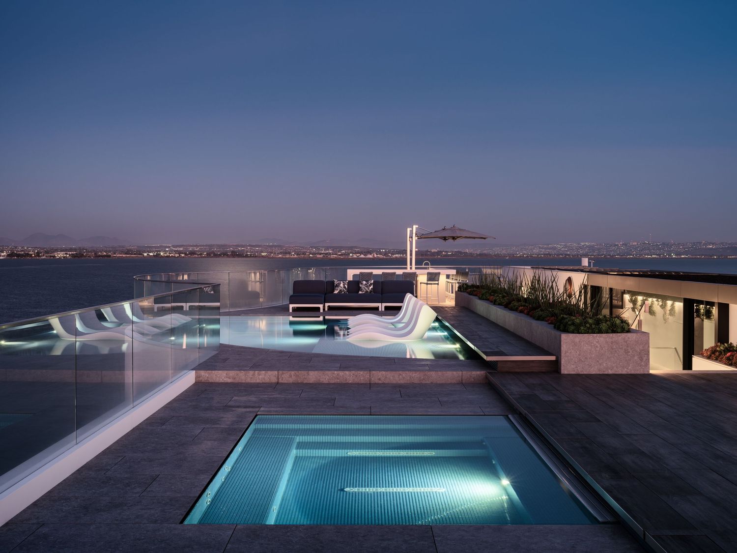 Rooftop pool at Coronado 3 The Point with infinity-edge design and expansive bay views at twilight