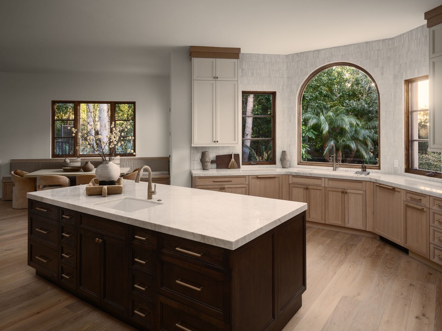 High-end kitchen photographed in Rancho Santa Fe luxury flip, showcasing custom cabinetry, stone island, and arched window views.