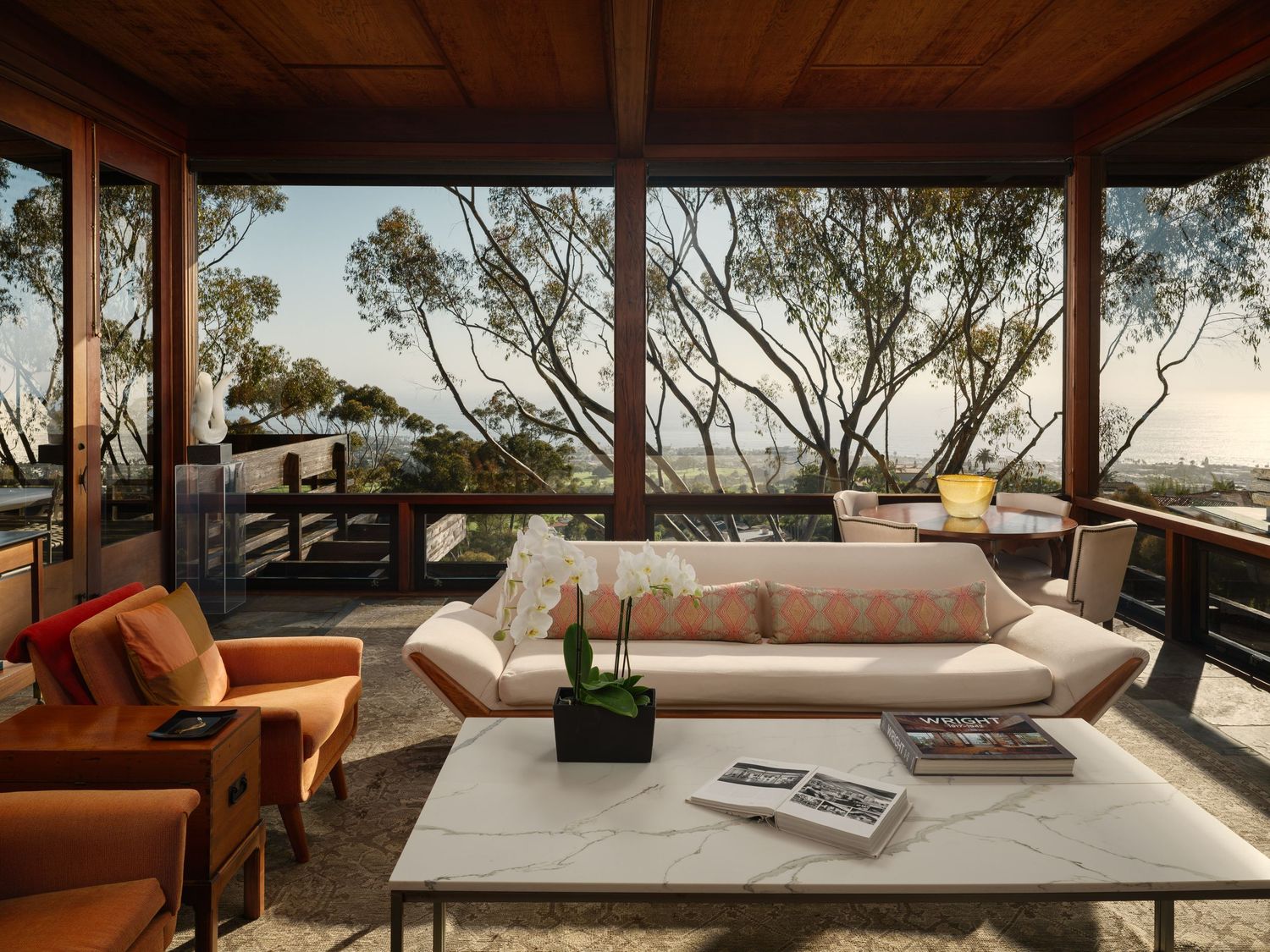 Interior of the Frederick Liebhardt-designed Romero House in La Jolla, with wood-framed glazing, built-ins, and coastal views.