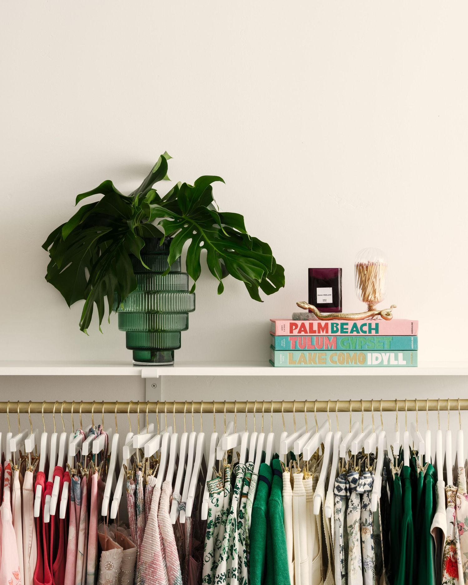 Styled display shelf and clothing rack inside Palma Boutique in Rancho Santa Fe, showcasing books, decor, and women’s apparel.