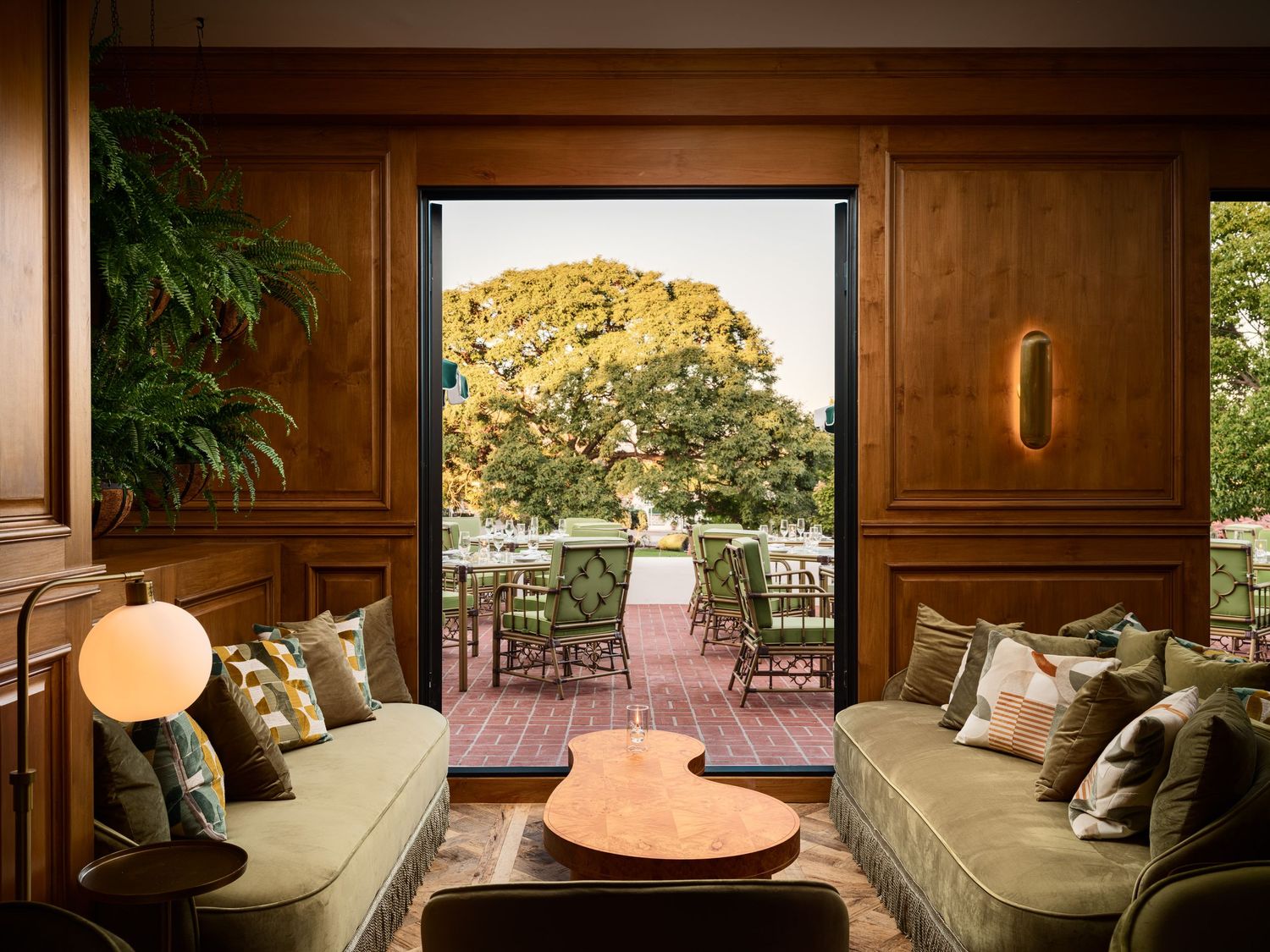 Elegant lounge interior at Bing’s Bar at The Inn at Rancho Santa Fe with wood paneling, cozy seating, and garden terrace views.
