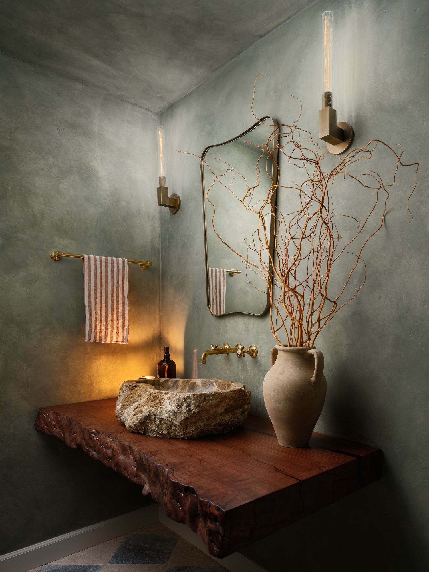 Moody La Jolla powder room with limewash walls, live-edge wood vanity, stone sink, and sculptural branches in architectural interior photo