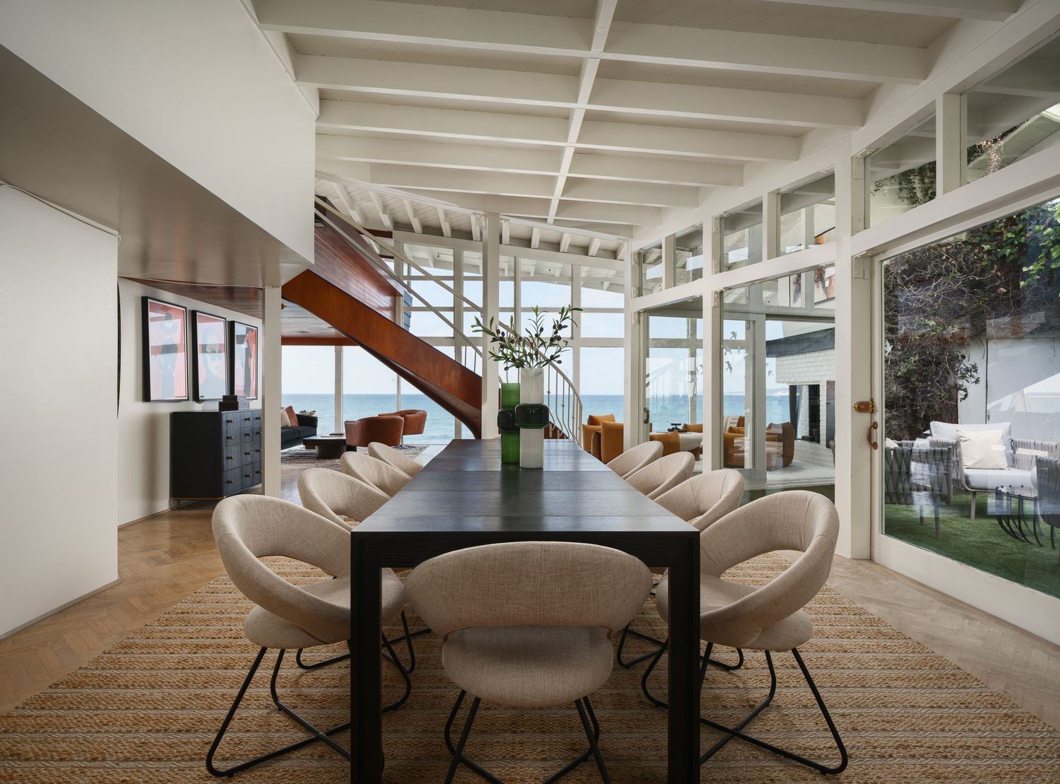Open-plan dining space at 1890 Spindrift Drive designed by architect William Kesling, featuring exposed beams, glass walls, and ocean views.