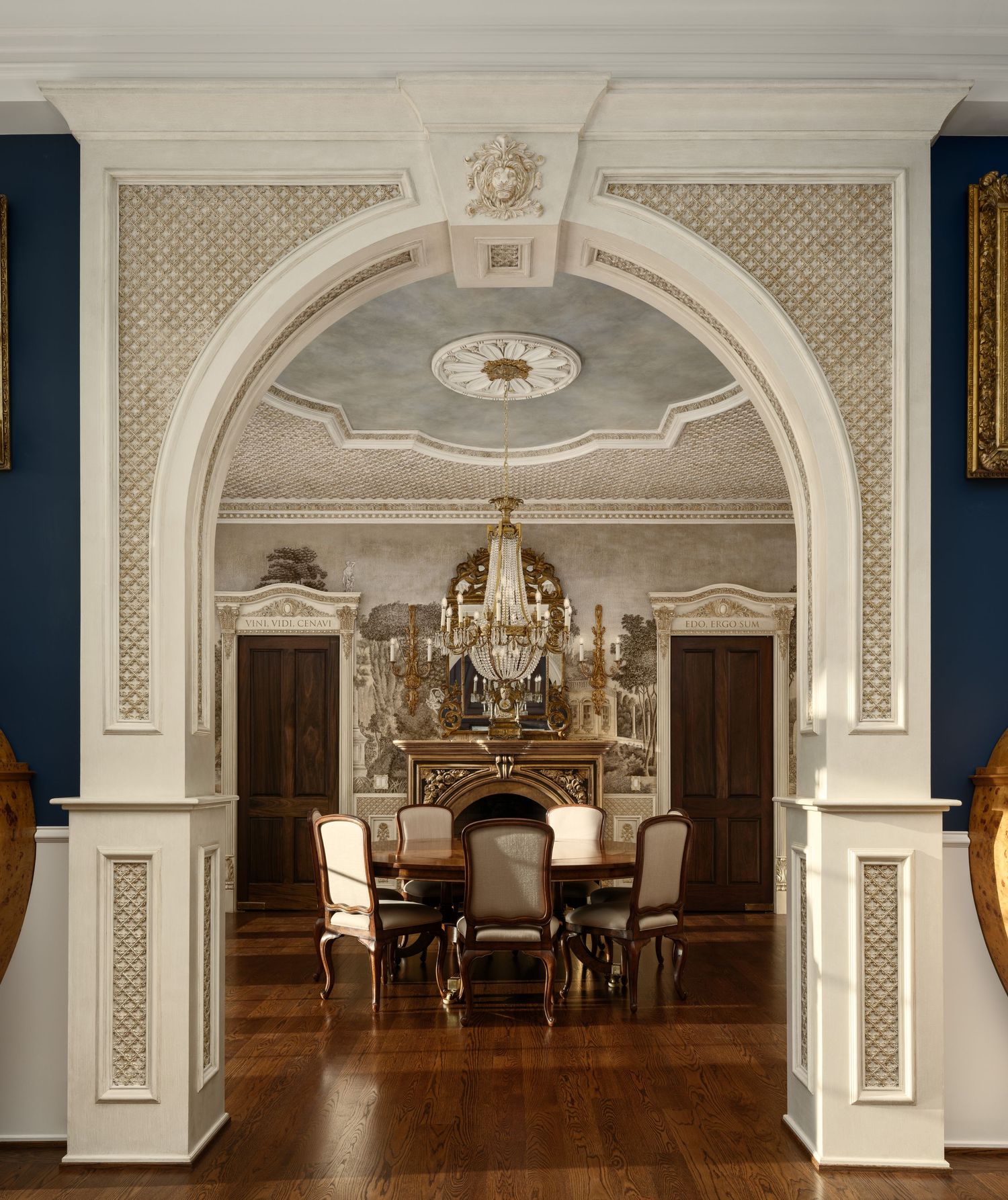 View into the Fielding House dining room framed by an ornate white archway with detailed plasterwork and warm wood accents.