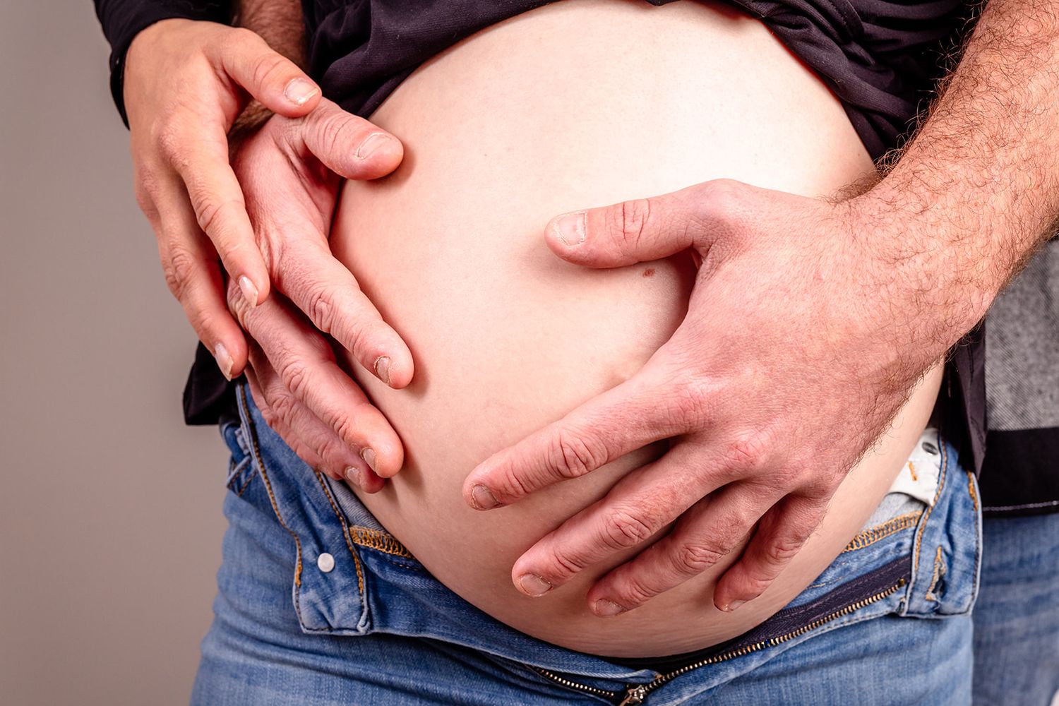 Person in jeans showing their stomach and sides in a progression of weight loss transformation photos.