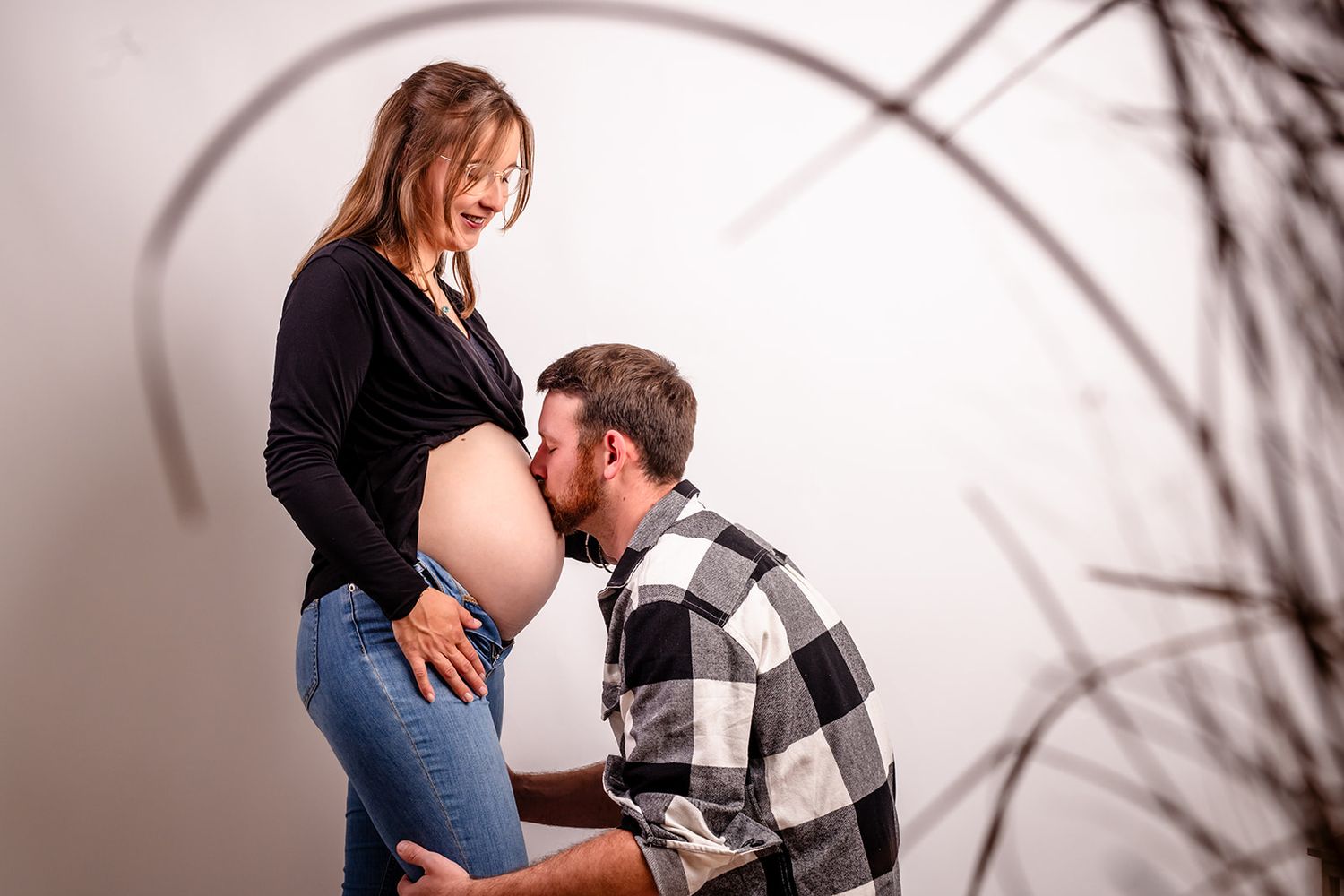 A series of intimate maternity photos showing tender moments between expectant parents in a natural outdoor setting.