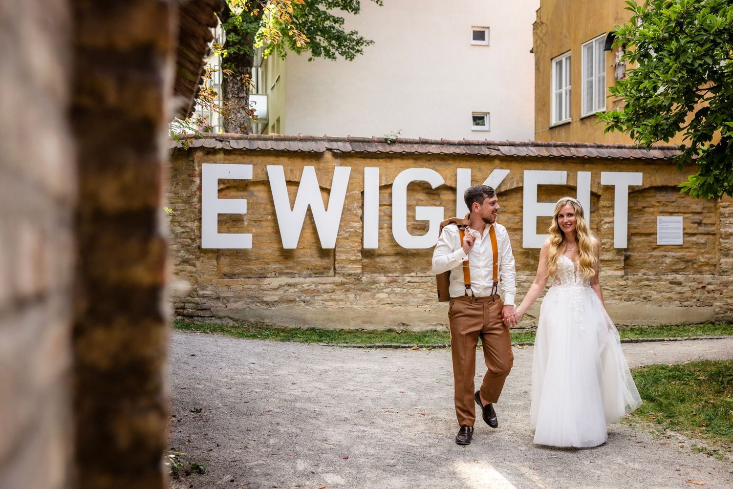 Brautpaar beim Spaziergang vor der Ewigkeitswand in Augsburg – Hüttner Fotografie