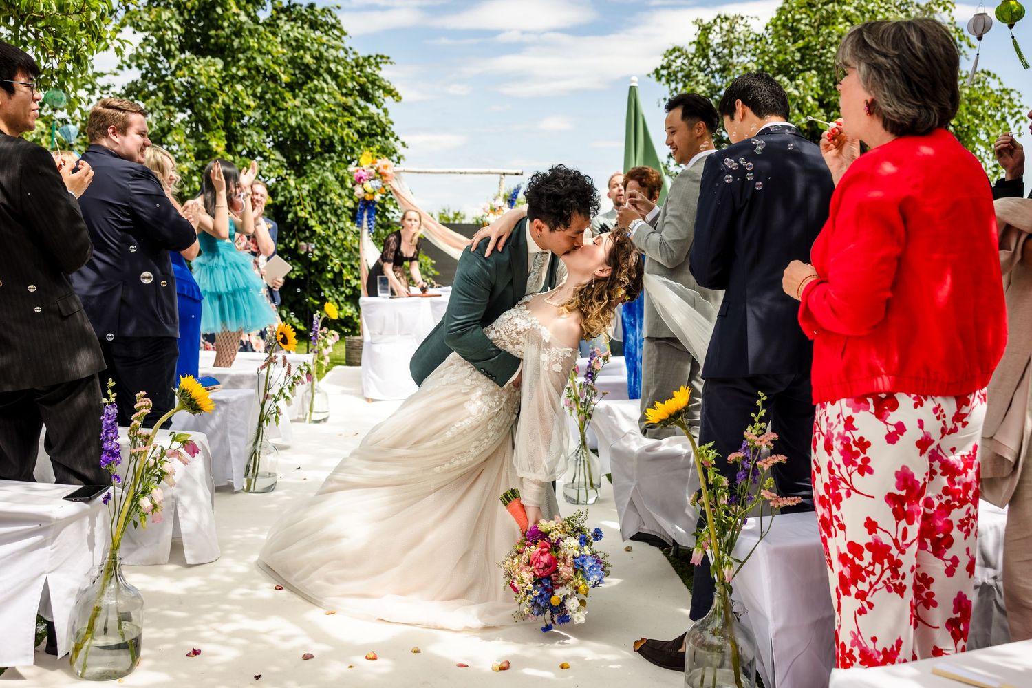 Wedding guests dancing together on an outdoor patio during a celebration.