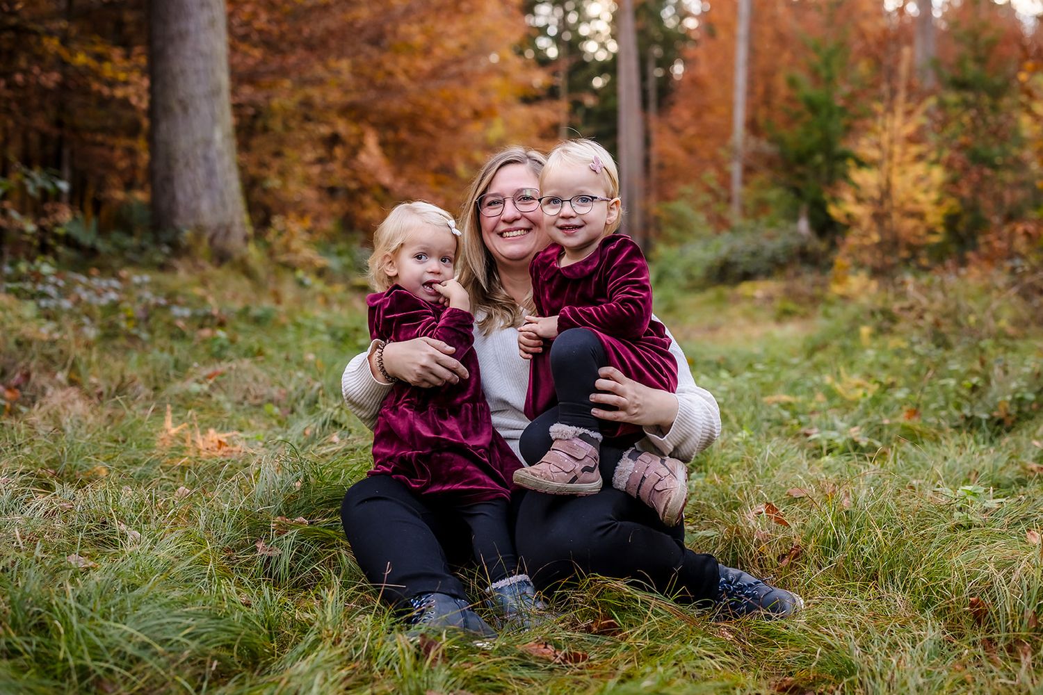 A series of autumn outdoor photos showing people sitting on grass with warm fall colors and trees in the background.