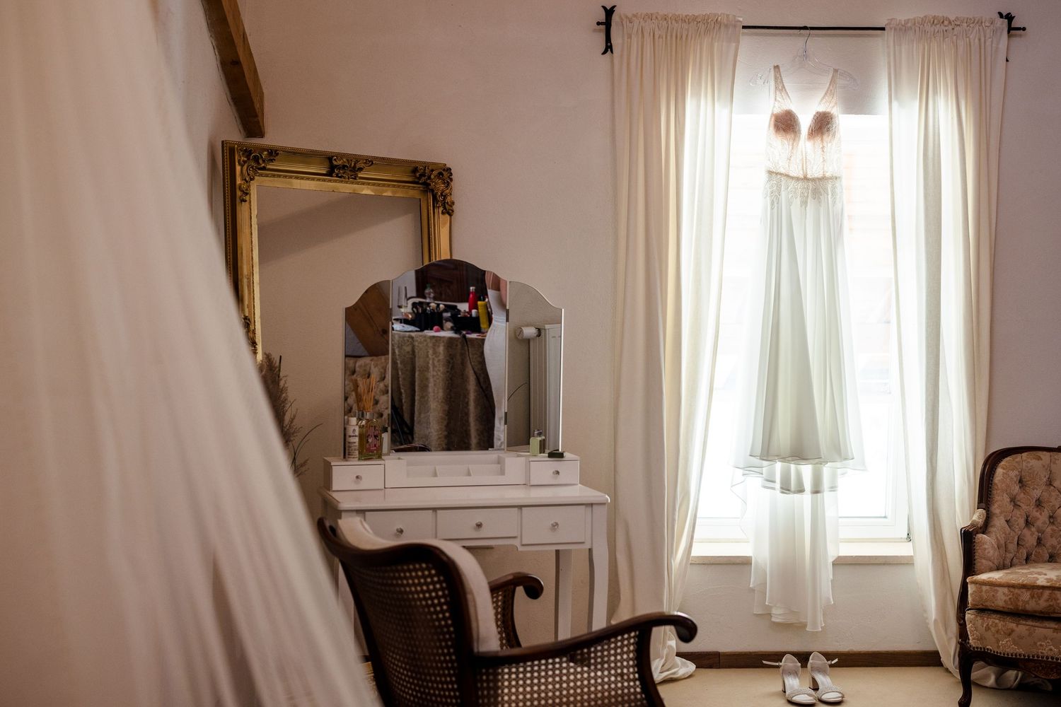 A bright and airy white bedroom with elegant furniture, sheer curtains, and a classic vintage-style decor theme. Fotografiert am Hofgut Sick
