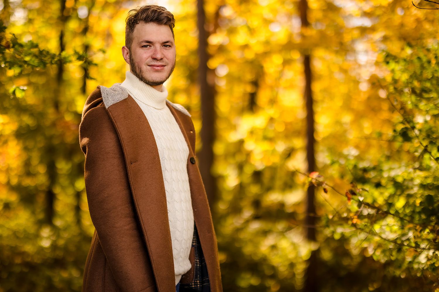 Portrait session in autumn forest with golden leaves creating magical backdrop.