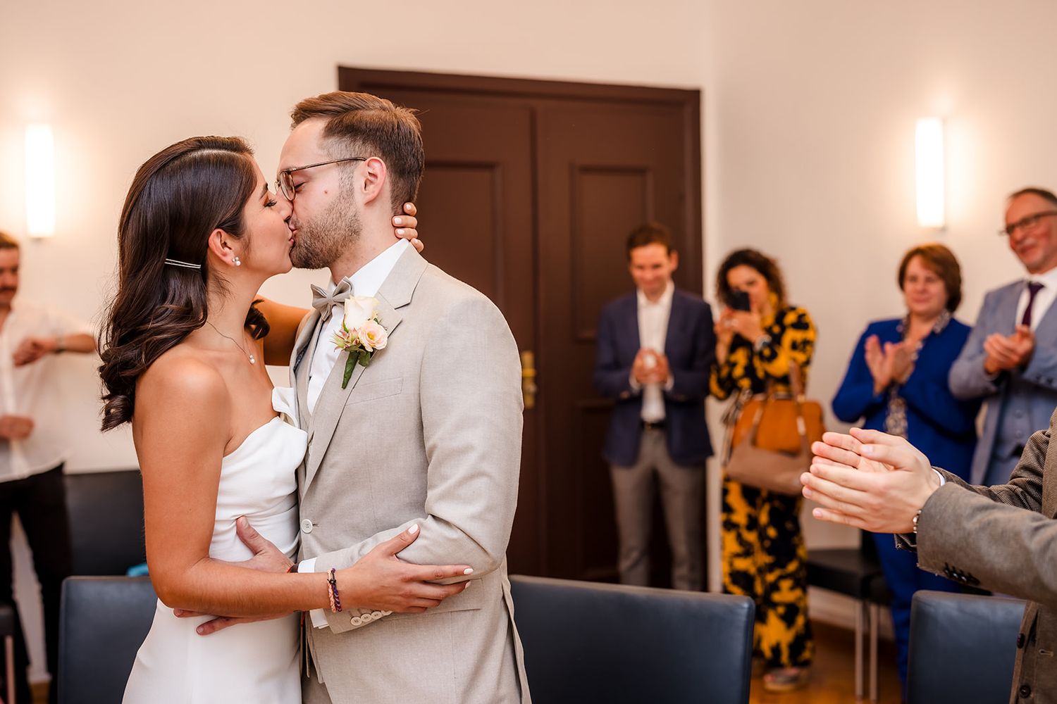 Indoor wedding reception celebration with guests in background.