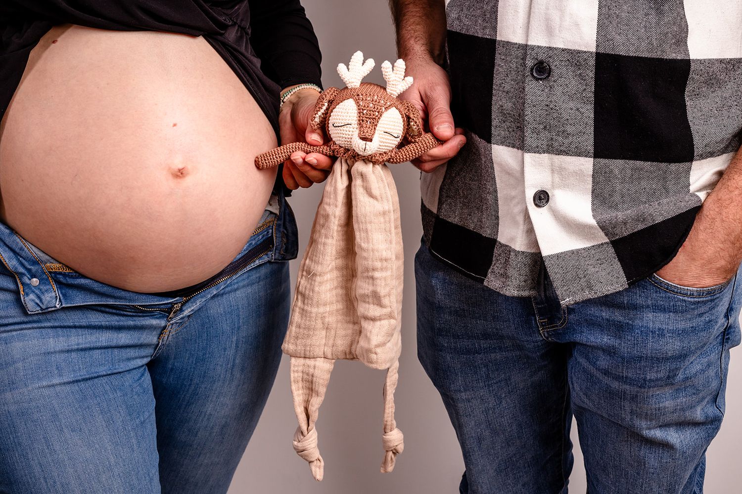 Close-up photos of a pregnant belly with hands resting on it showing progression of pregnancy growth over time.