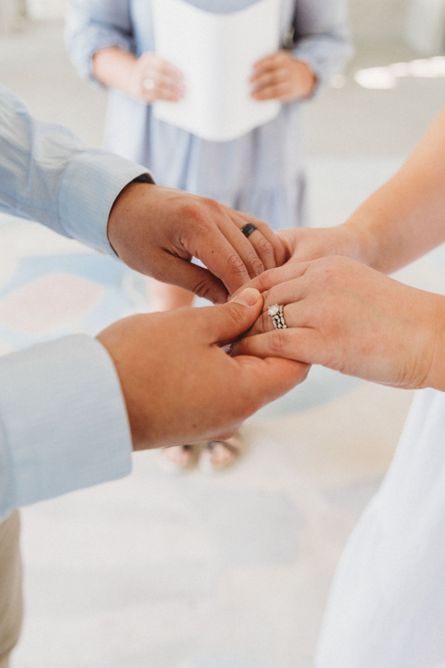 Close-up sequence of hands exchanging wedding rings during a ceremony.