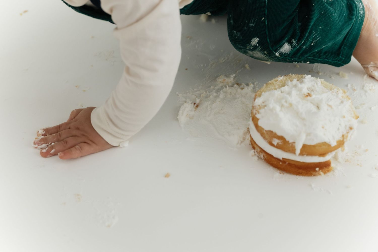 A person's hands spread flour on a white surface while baking in the kitchen.