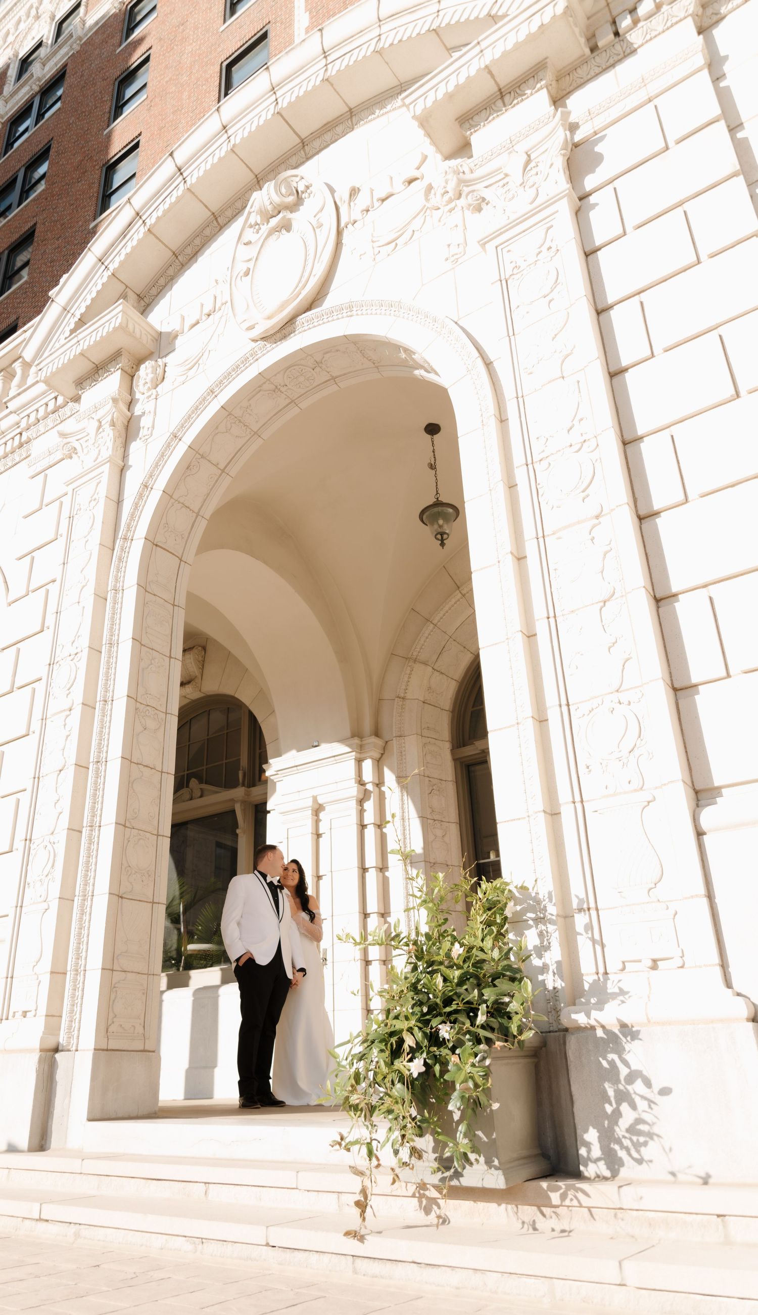 Elegant white stone archways with classical architecture creating a romantic wedding venue backdrop.