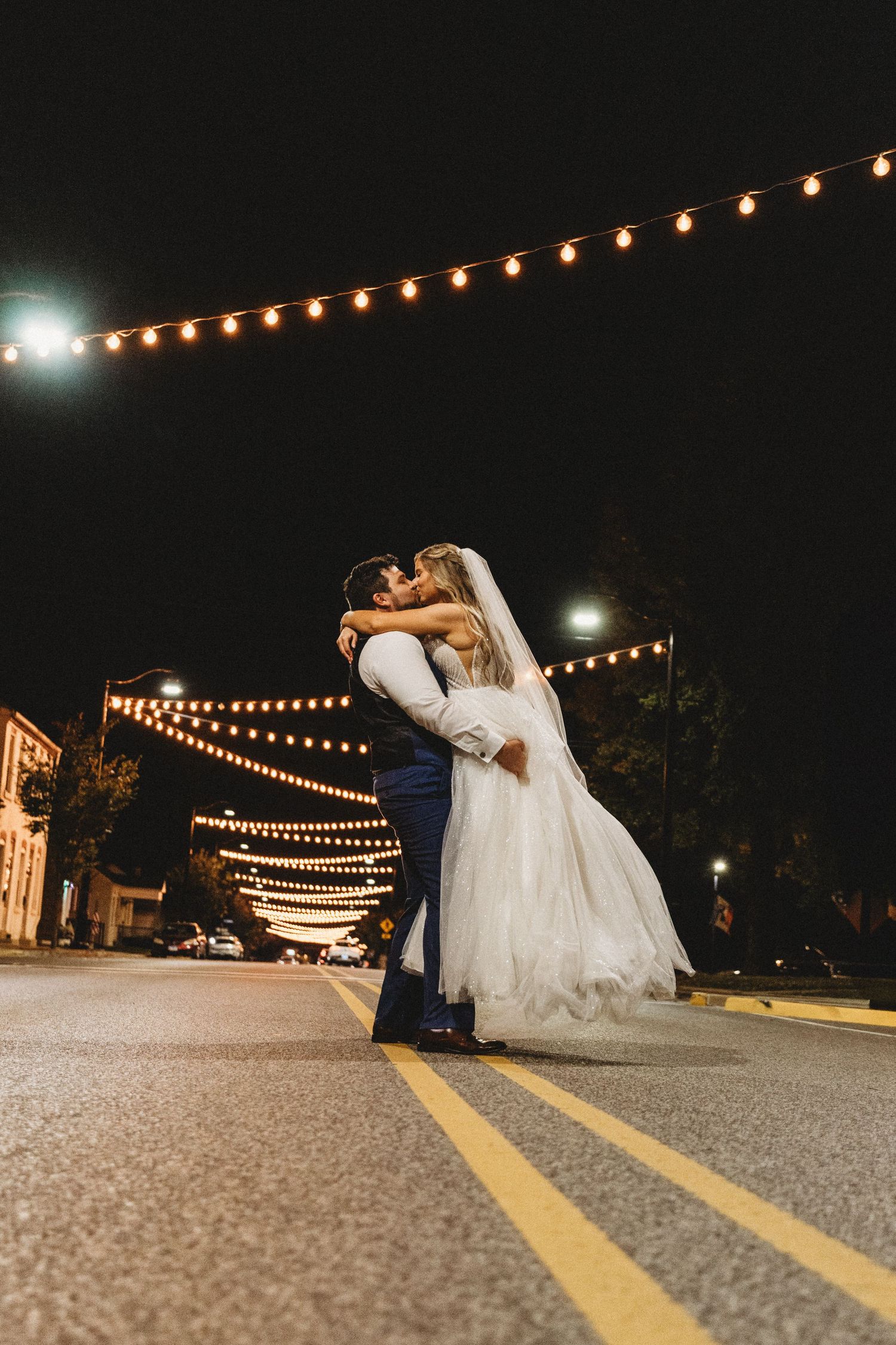 A romantic nighttime wedding scene with string lights creating a magical atmosphere.
