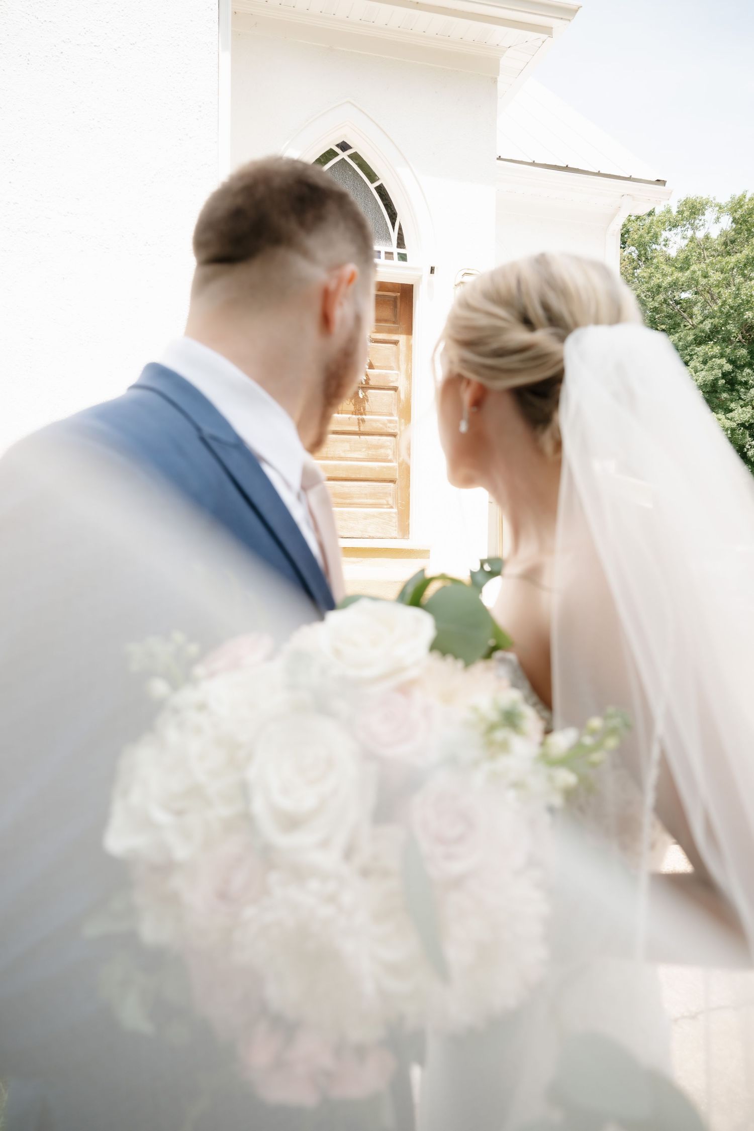 Soft focus wedding photo with delicate white flowers in the foreground.