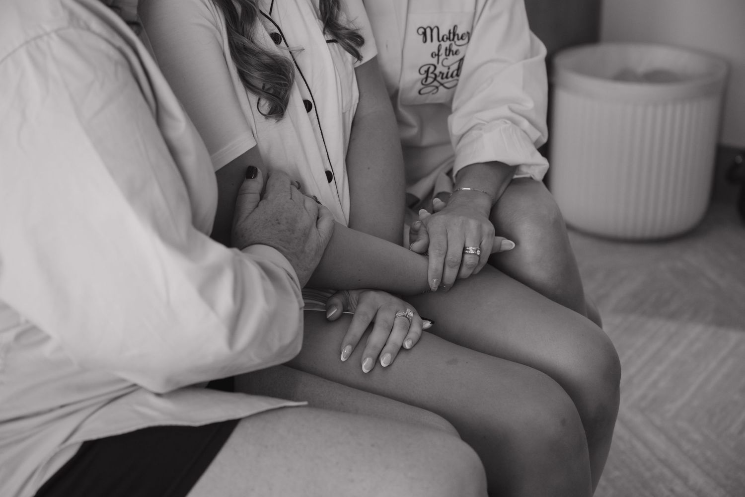 Close-up black and white images of hands holding and caressing during an intimate maternity photo session.