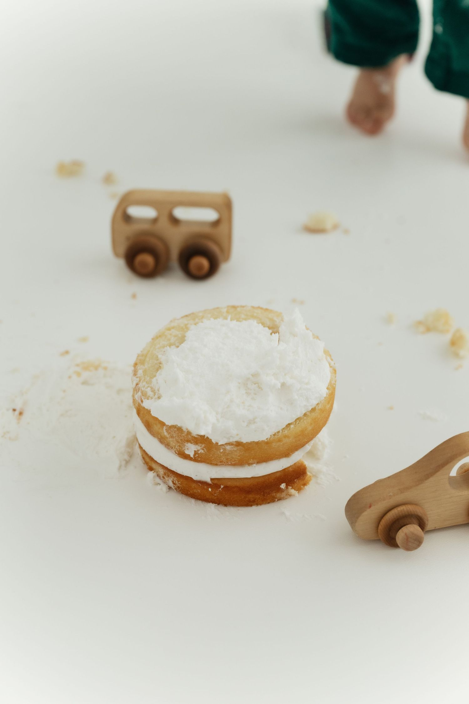 Close-up view of wooden toy cars and white powdery substance on a light-colored surface.