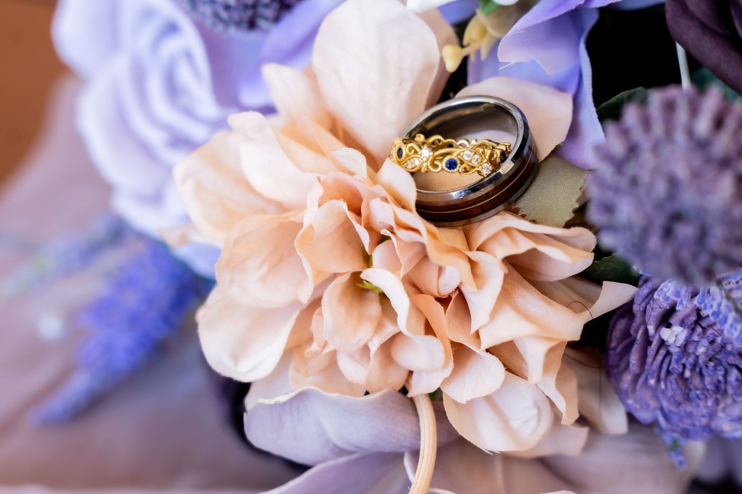 Delicate peach and lavender flowers arranged in a romantic wedding bouquet with soft, dreamy lighting.