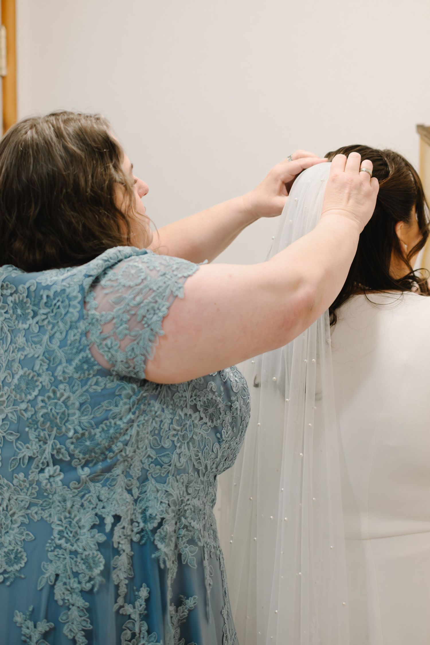 Person in a blue lace dress leans forward to adjust curtains in a sequence of progressive movements.