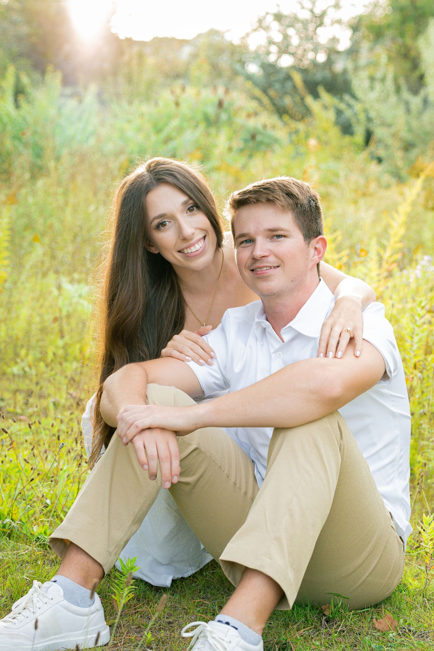 Couple relaxing and cuddling on grass in a summer garden setting.
