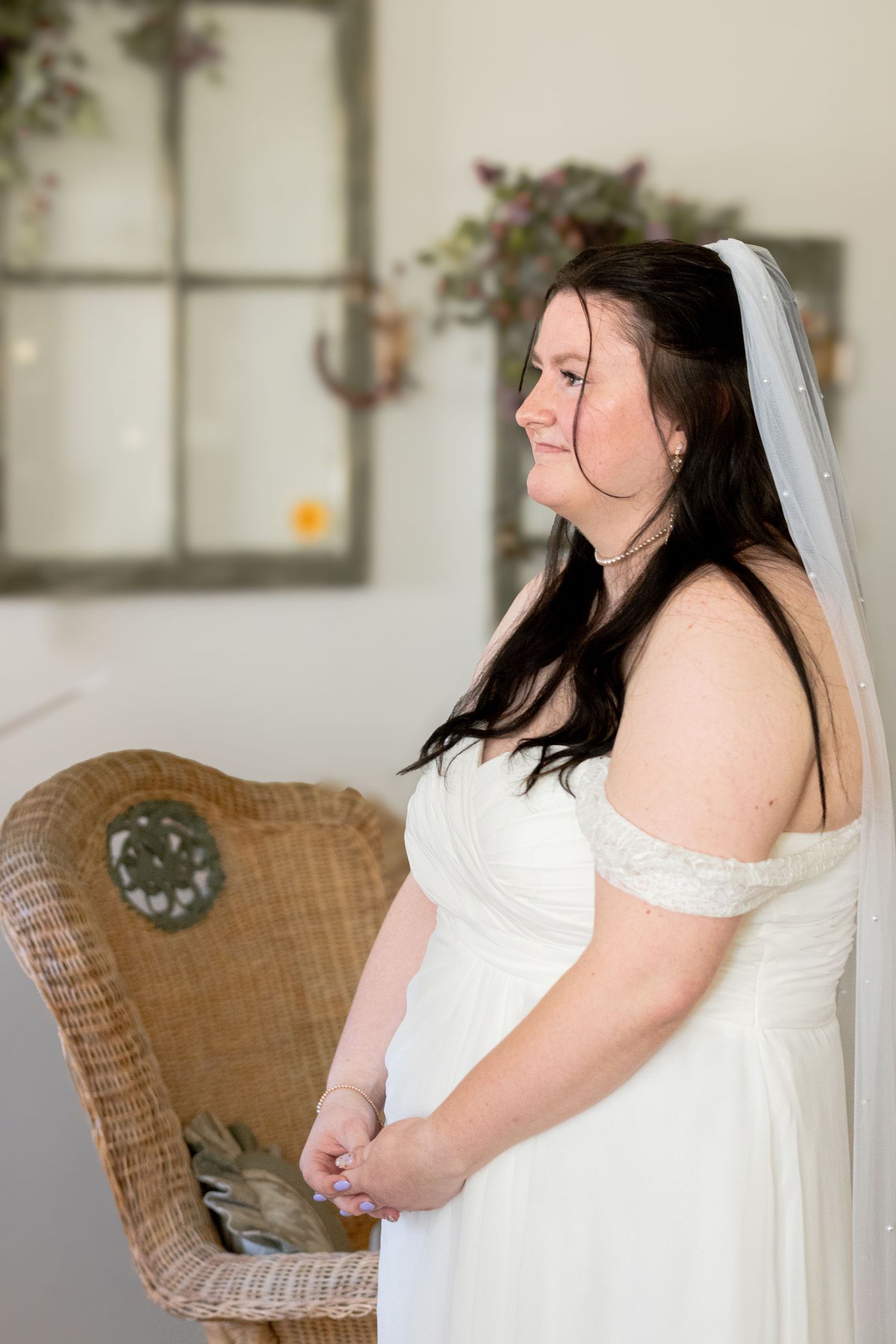 Bride in white wedding dress listening to her Groom’s vows.