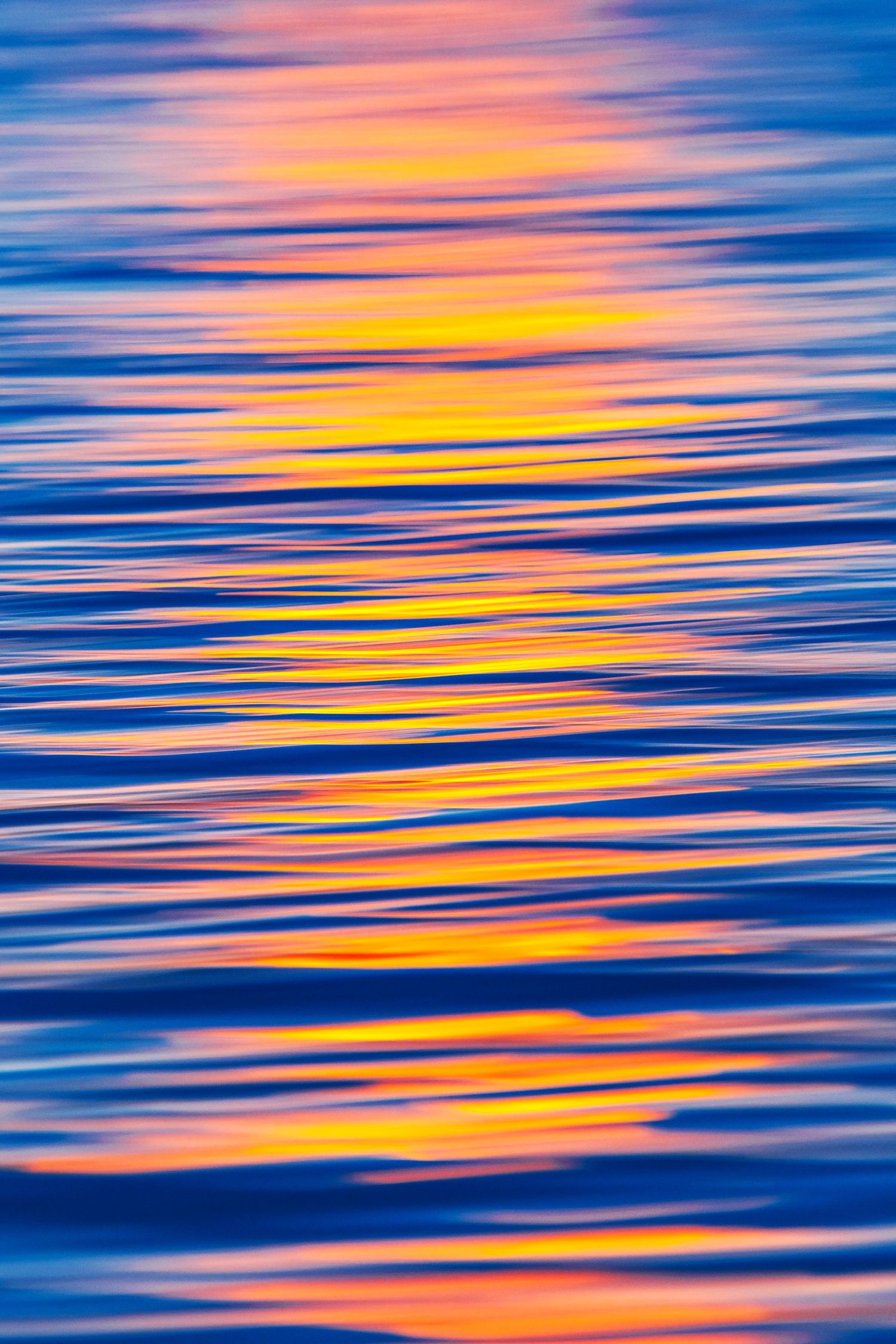 Abstract water reflection with pink and orange sunset colors creating rippled patterns.