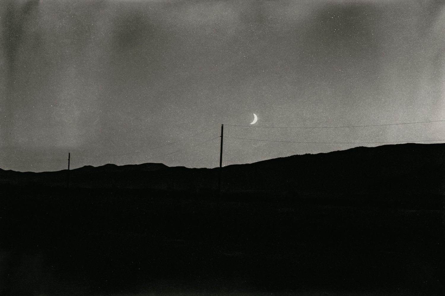 Minimalist black and white landscape with rolling hills at dusk.