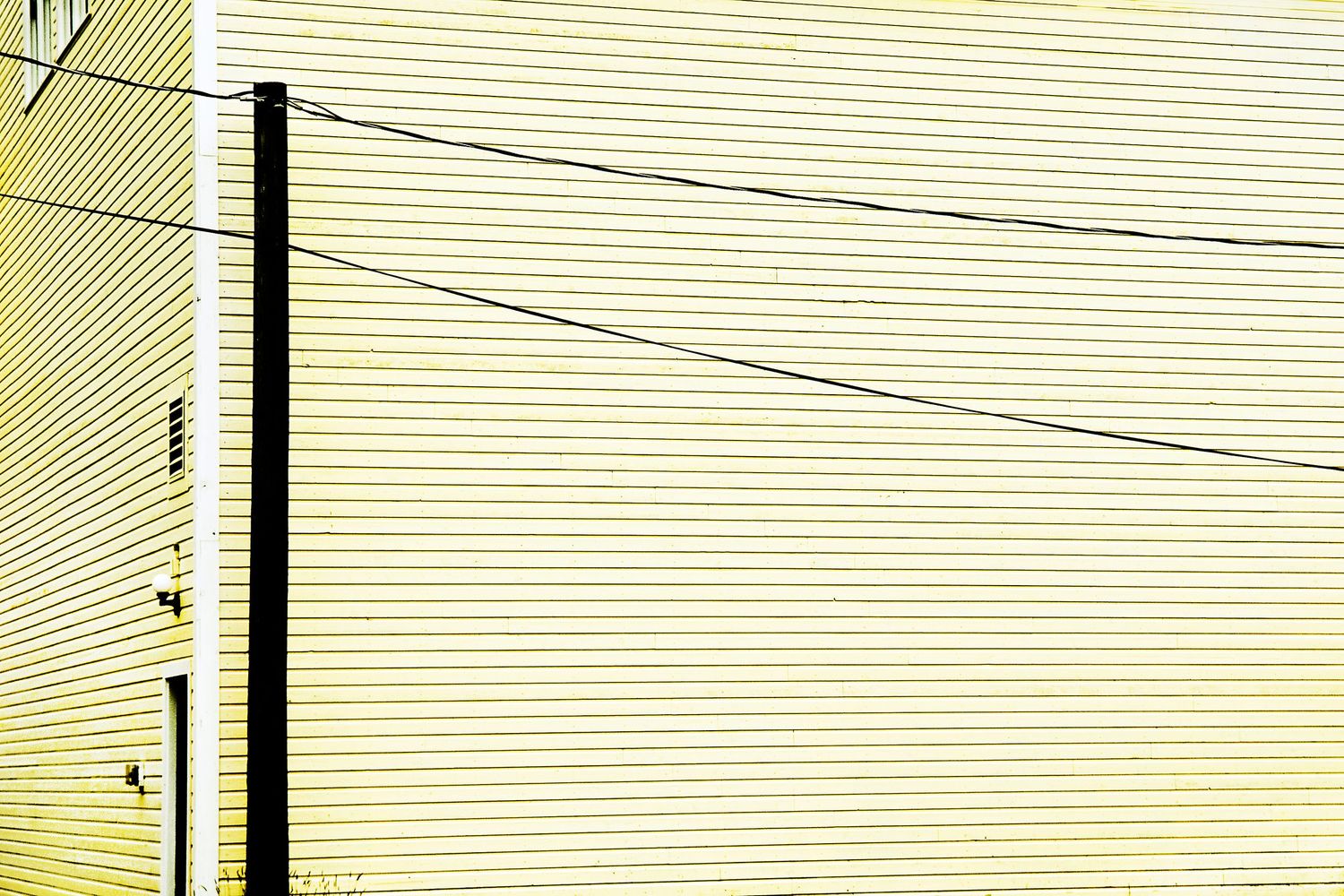 Yellow siding pattern on a house exterior with parallel horizontal lines.