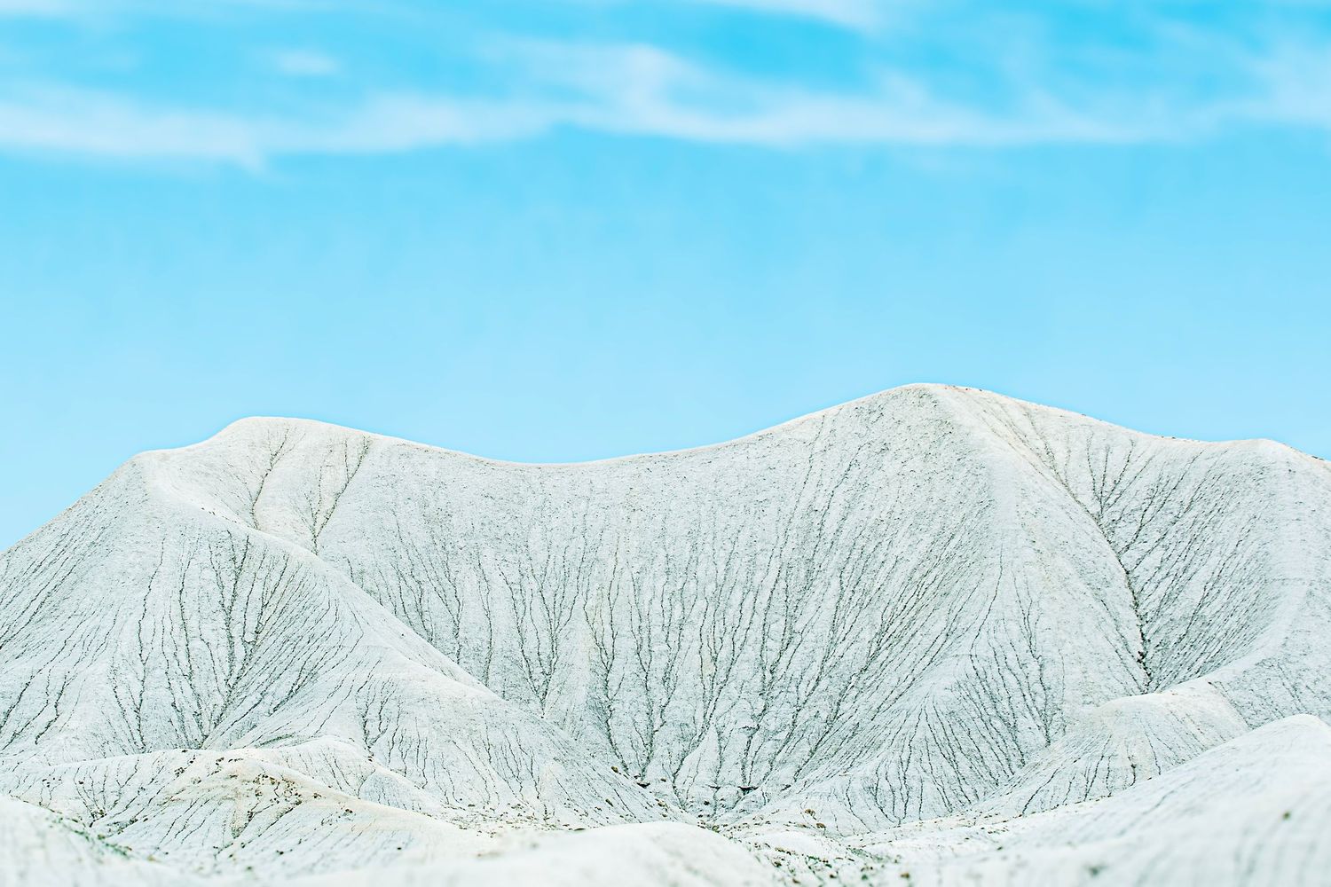 Mountain ridges stretch across the horizon under a bright blue sky.
