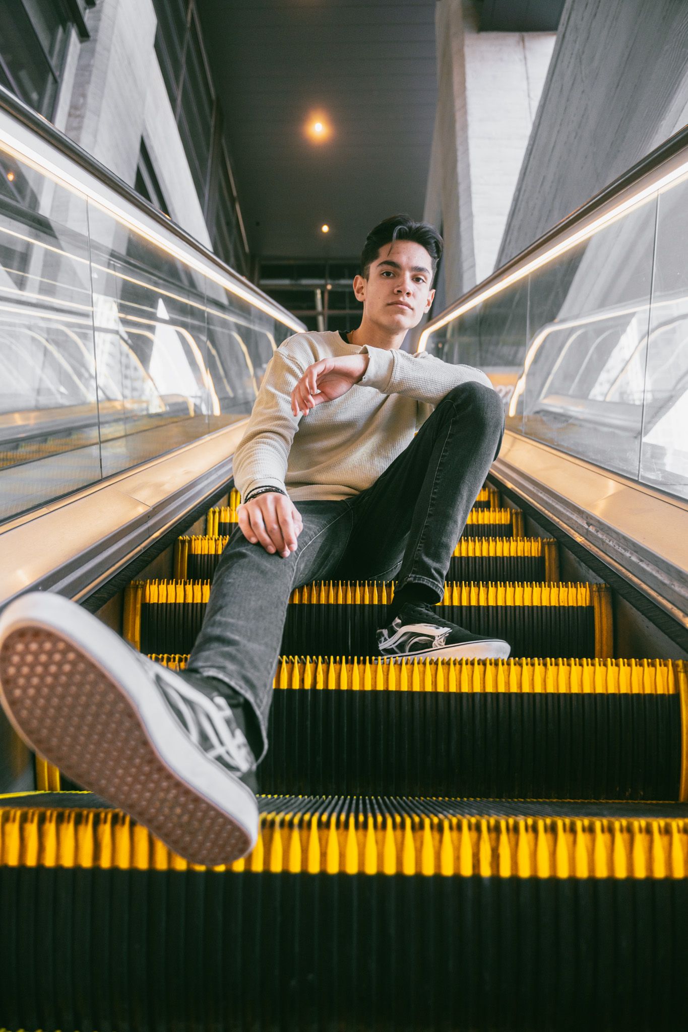 Creative escalator photoshoot showing different poses and angles with illuminated yellow steps.