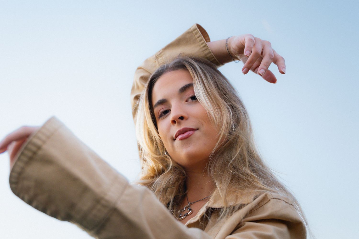 Outdoor portrait series against bright blue sky wearing casual attire.