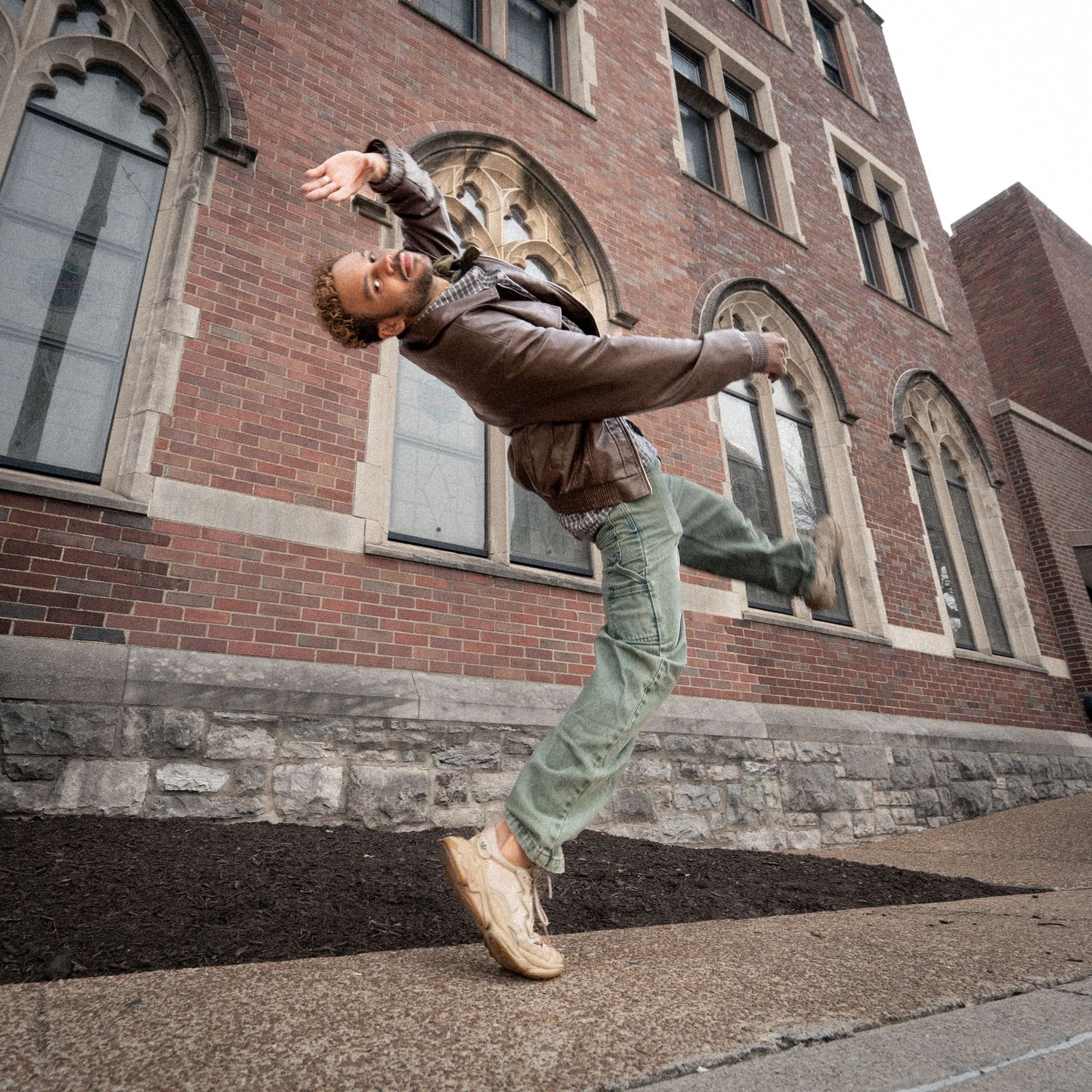 Series of dynamic dance poses captured against a brick building exterior.