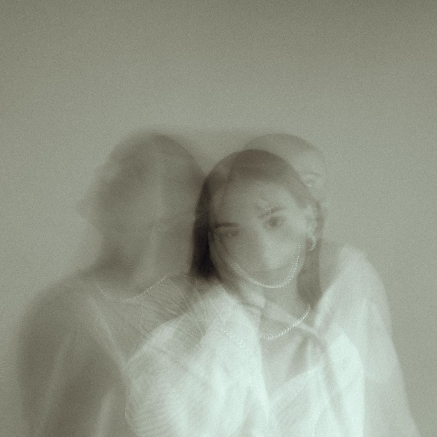 Abstract double exposure portrait in white with ethereal motion blur effect.